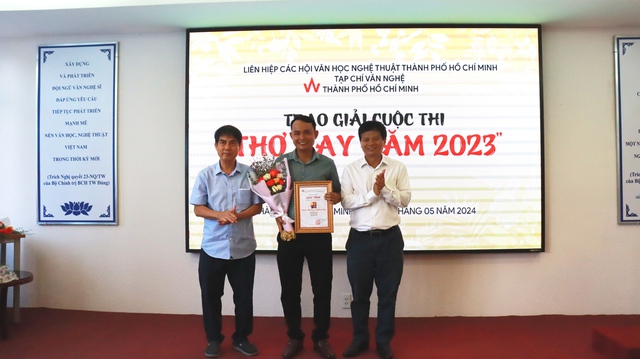 Chủ tịch Liên hiệp các Hội VHNT TP.HCM Nguyễn Trường Lưu (trái) và Phó chủ tịch Hội Nhà báo Việt Nam Trần Trọng Dũng trao giải nhất cuộc thi Thơ hay năm 2023 cho nhà thơ Nhiên Đăng