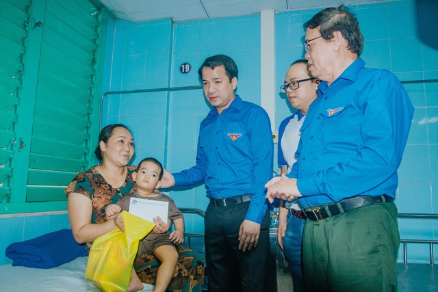 Anh Ngô Văn Cương và ông Vũ Trọng Kim (bên phải) thăm, tặng quà cho trẻ em tại Bệnh viện Hữu nghị Việt Nam - Cuba Đồng Hới
