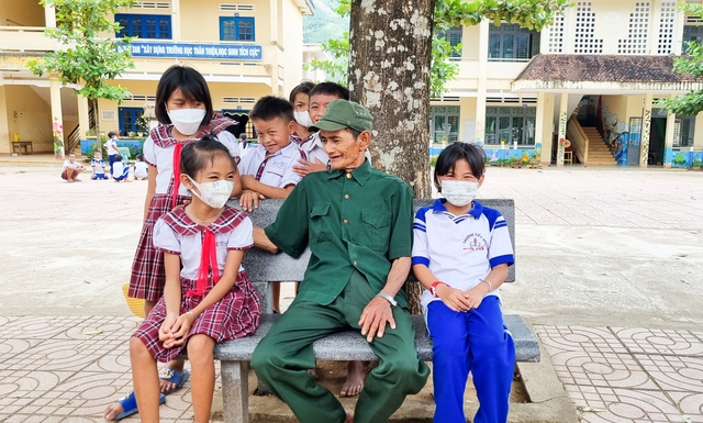 Ông Phạm Thanh Mong vui vẻ bên các em học sinh Trường tiểu học Ba Tô