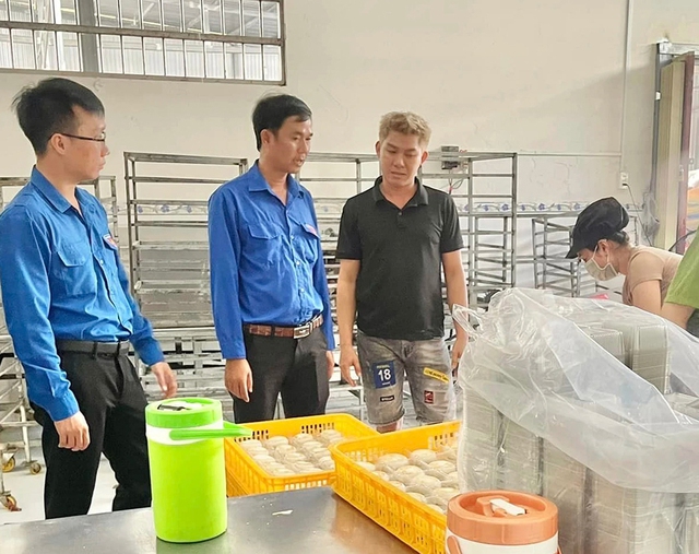 Anh Hùng (thứ 3 từ trái qua) giới thiệu khâu sản xuất bánh pía truyền thống đến đoàn tham quan của Huyện đoàn Thạnh Trị