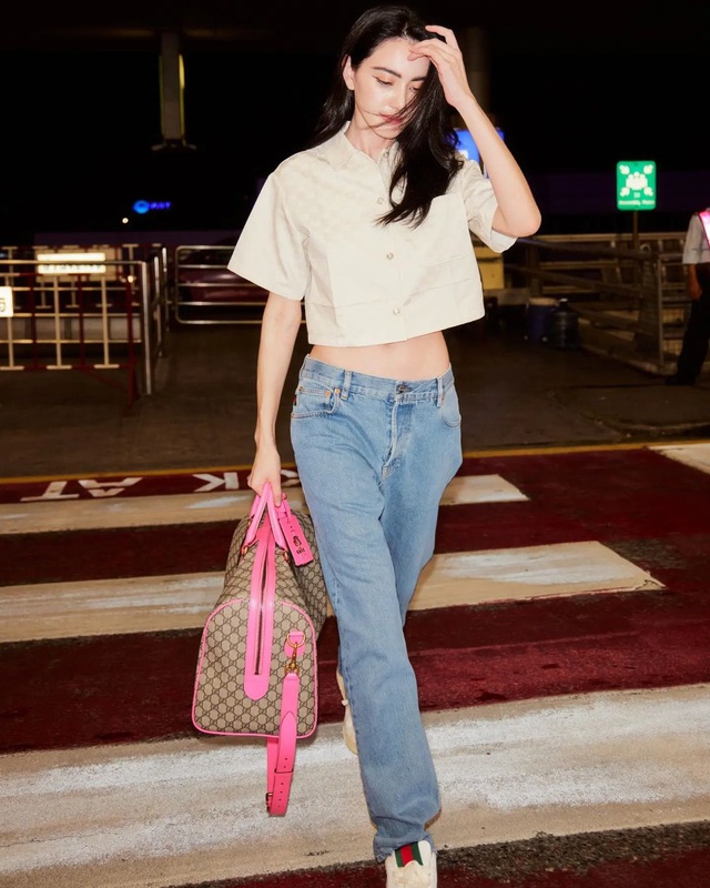 Ngôi sao thời trang xứ sở chùa vàng Mai Davika lăng xê quần jeans cạp trễ, áo sơ mi crop top và sneakers khi di chuyển ra sân bay cùng chiếc túi oversized màu hồng họa tiết monogram. Dáng quần cạp trễ, ống đứng phù hợp với những cô nàng có dáng thanh mảnh và vòng eo phẳng; khi phối cùng áo lửng sẽ tạo nên bản phối vừa thoáng mát vừa sành điệu lại có thể tôn hình thể theo cách tự nhiên