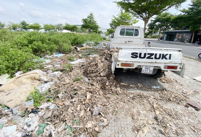 Lực lượng chức năng buộc T.H.N gom rác thải đã đổ xuống vỉa hè khu đô thị