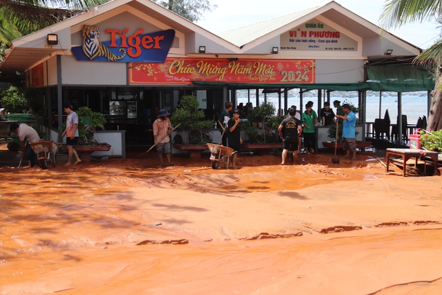 Một nhà hàng thuộc điểm sạt lở P.Mũi Né bị cát vùi sâu khoảng 1 m. Nhà hàng đang cho nhân viên tự cào cát ra ngoài