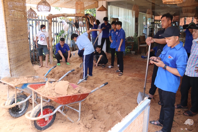 Lực lượng đoàn viên, thanh niên giúp dân dọn sạch nhà cửa do cát tràn vào nhà trong đêm qua