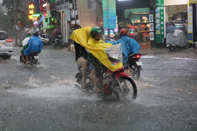 Người dân khổ sở khi chạy xe dưới trời mưa to