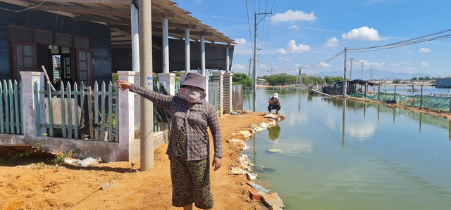 Gia đình bà Lên đổ đất chắn cao để ngăn nước tràn vào nhà