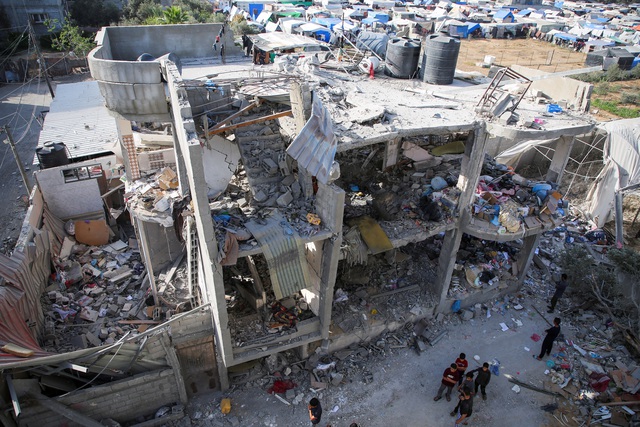 Một tòa nhà bị thiệt hại do Israel tấn công, cạnh khu lều trại của người Palestine ở thành phố Rafah