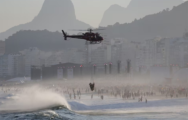 Trực thăng vận chuyển nhân viên cứu hộ và một người được giải cứu khi mọi người tập trung tại bãi biển Copacabana