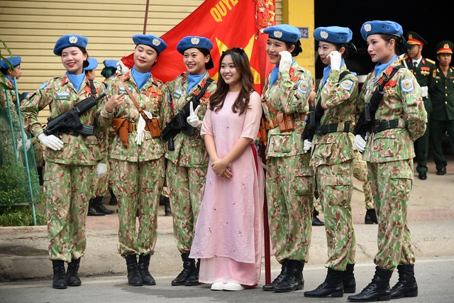 Một cô gái tranh thủ chụp ảnh cùng các chiến sĩ nữ gìn giữ hòa bình