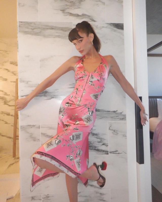 Trước đó khi tổ chức buổi tiệc ra mắt dòng đồ uống mocktail tại Los Angeles, Mỹ, Bella Hadid cũng chọn váy cổ điển. Cô trông thật xinh đẹp với chiếc váy lụa màu hồng in họa tiết của Roberto Cavalli
