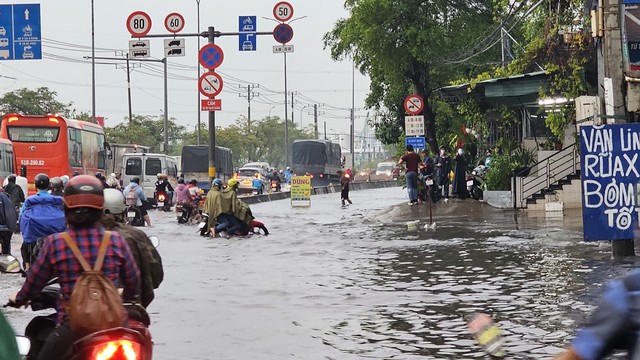 Mưa ngập ở TP.HCM: Bán buôn, đi lại khổ ải trong dòng nước đen gây ngứa- Ảnh 5.