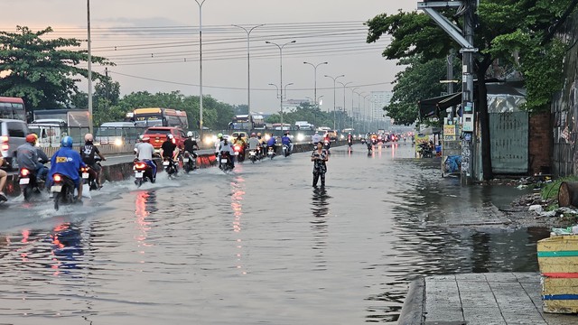 Mưa ngập ở TP.HCM: Bán buôn, đi lại khổ ải trong dòng nước đen gây ngứa- Ảnh 4.