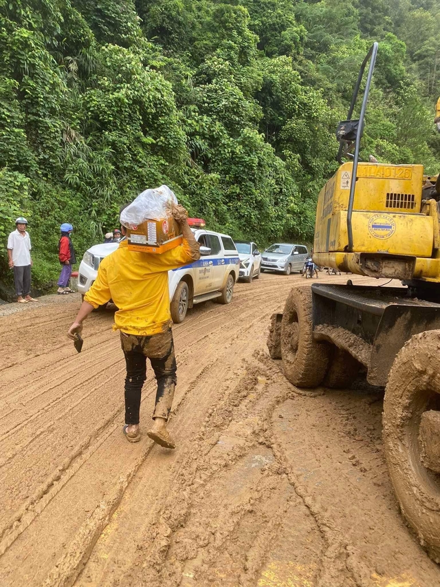 Người dân giúp chở xe máy, hàng hóa qua đoạn ngập- Ảnh 2.