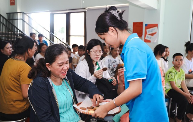 Trong lúc chờ làm thủ tục nhập học, các học sinh mới và người thân được các học sinh cũ của trường mời thưởng thức món bánh quy tự làm