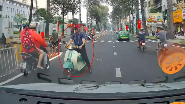 Người đàn ông ngang nhiên phóng xe Vespa ngược chiều trên phố- Ảnh 1.