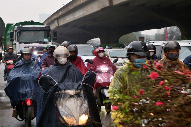 Người dân đội mưa về quê ăn tết, cửa ngõ phía nam Hà Nội ùn tắc- Ảnh 1.