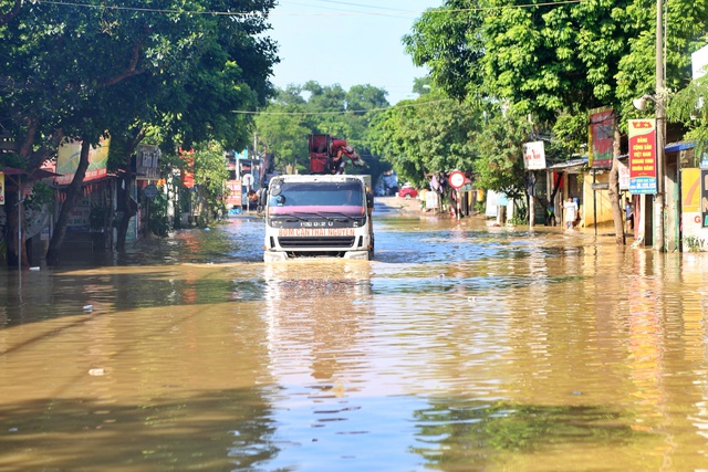 Bộ Công an điều động xe đặc chủng lội nước hỗ trợ dân vùng lũ Hà Nội - Ảnh 1.