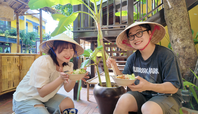 Anh Munki Kim cùng bạn gái (đều là du khách Hàn Quốc) trải nghiệm làm món mì Quảng tại phố cổ Hội An. ẢNH: LÊ NAM Anh Munki Kim cùng bạn gái (đều là du khách Hàn Quốc) trải nghiệm làm món mì Quảng tại phố cổ Hội An.