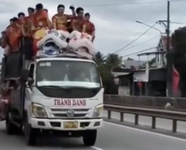 Chở đoàn múa lân trên nóc và thùng xe tải, nữ tài xế bị xử phạt- Ảnh 1.