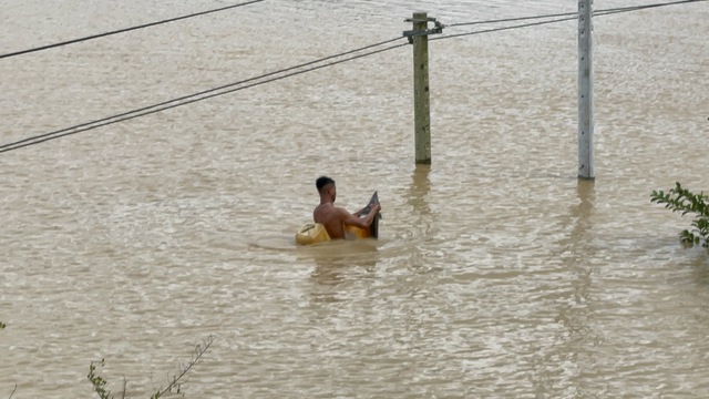 Đắk Lắk: Người dân liều mình câu cá tầm giữa dòng nước lũ - Ảnh 1.