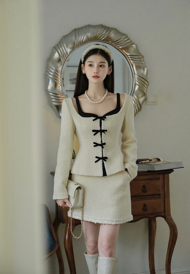 Tựa như một quý cô Anh quốc thanh nhã, bộ tweed kem điểm nơ đen mang vẻ đẹp cổ điển mà vẫn thời thượng. Phom áo ôm nhẹ cùng chân váy ngắn tạo nét lịch thiệp, rất hợp cho những khoảnh khắc cần sự trang trọng. ẢNH: ELA DESIGN