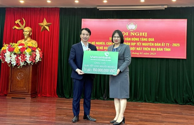 Bà Hoàng Thị Kim Ngân - Phó giám đốc, Chủ tịch Công đoàn cơ sở (bên phải) đại diện Vietcombank Hải Dương trao biển tượng trưng tặng quà Tết cho người nghèo thông qua Ủy ban MTTQ tỉnh