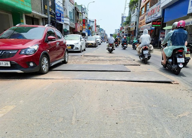 Những tấm sắt bị chênh trên đường - Ảnh 1.
