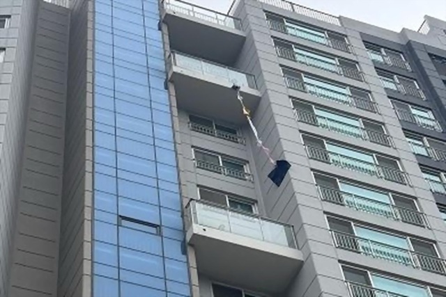 Người phụ nữ mắc kẹt gần 2 ngày trên ban công cầu cứu - Ảnh 1.