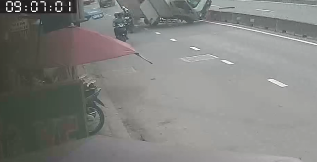 Ớn lạnh clip xe tải tông dải phân cách, suýt đè trúng 2 người đi đường - Ảnh 1.