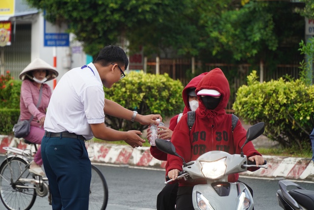 Vĩnh Long: Tình nguyện viên trú mưa 'gặm bánh mì' trong lúc thí sinh thi- Ảnh 8.