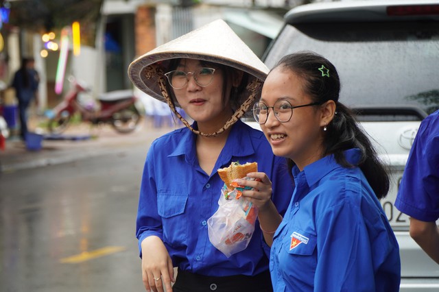 Vĩnh Long: Tình nguyện viên trú mưa 'gặm bánh mì' trong lúc thí sinh thi- Ảnh 5.