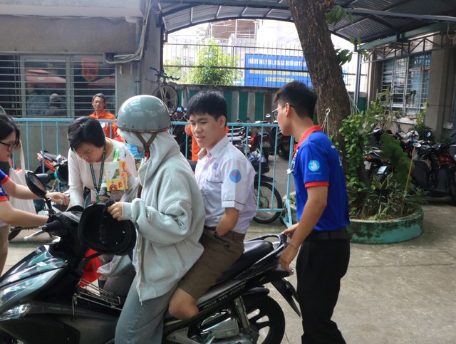 Tình nguyện viên cõng thí sinh mất tay, chân đi thi tốt nghiệp THPT 2025 - Ảnh 2.