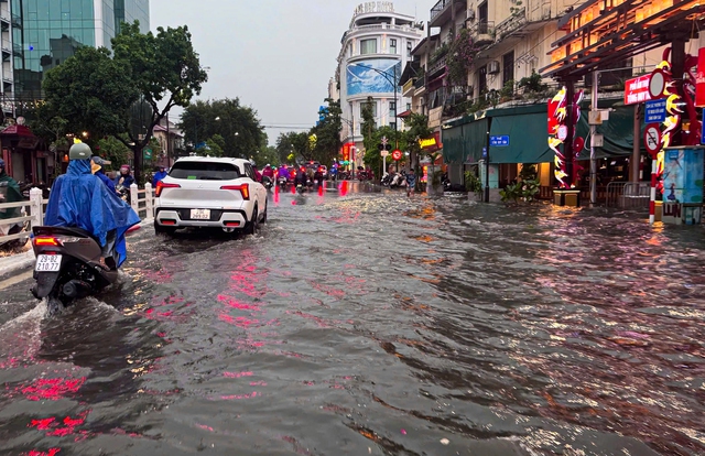 Đường phố Hà Nội ngập sâu sau cơn mưa lớn, phương tiện 'bơi' trong biển nước - Ảnh 1.
