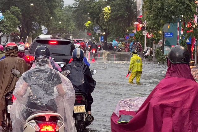Đường phố Hà Nội ngập sâu sau cơn mưa lớn, phương tiện 'bơi' trong biển nước - Ảnh 3.