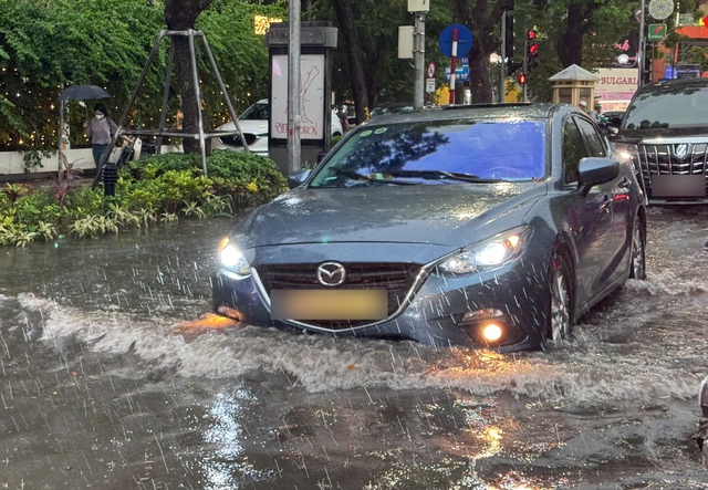 Đường phố Hà Nội ngập sâu sau cơn mưa lớn, phương tiện 'bơi' trong biển nước - Ảnh 4.