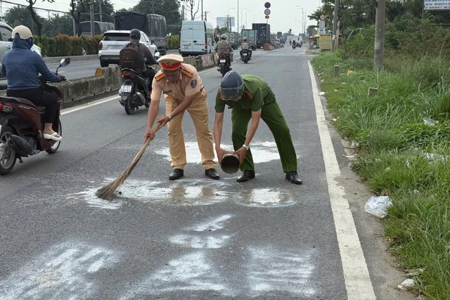 CSGT TP.HCM xóa dòng chữ 'bắn tốc độ' phun trên mặt đường Lê Quang Đạo - Ảnh 2.