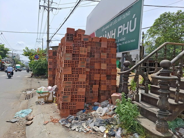Vật liệu xây dựng chất cao bên đường, gây nguy hiểm- Ảnh 1.