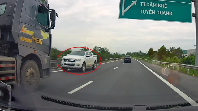 Xe bán tải liều lĩnh chạy ngược chiều cao tốc, bị xe tải ép đi lùi  - Ảnh 1.