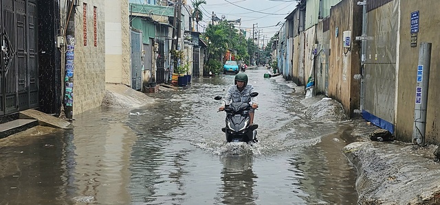 TP.HCM: Ngập sâu, người đi đường 'chôn chân' chờ nước rút - Ảnh 3. TP.HCM: Ngập sâu, người đi đường 'chôn chân' chờ nước rút - Ảnh 3.