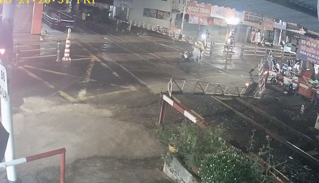 Thót tim xe máy lao đổ gác chắn, kẹt lại đường ray khi tàu sắp đến - Ảnh 1.