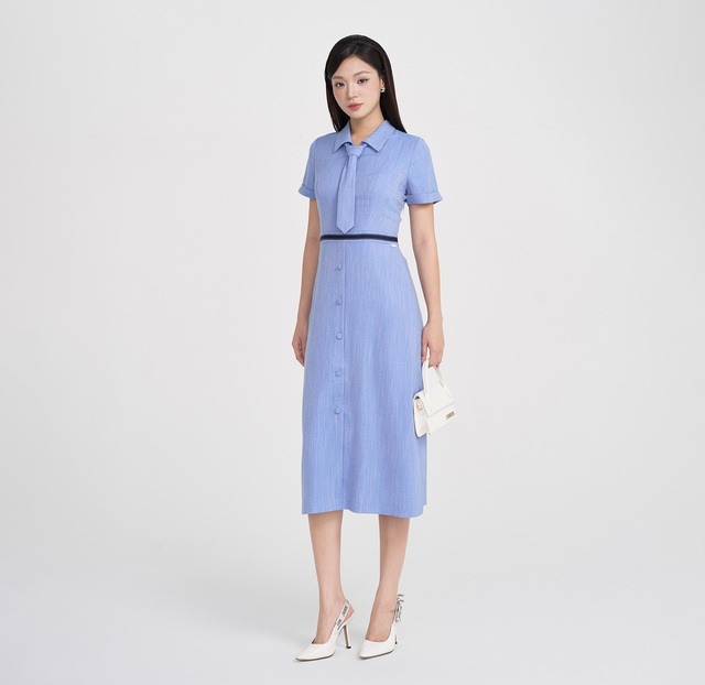 Váy sơ mi dáng dài với gam xanh pastel dịu mắt mang đến vẻ ngoài nhã nhặn, phù hợp với nhiều độ tuổi và phong cách. Phần cổ áo cổ điển kết hợp cùng chi tiết cà vạt cá tính tạo thêm điểm nhấn ấn tượng