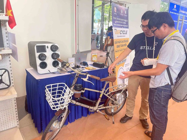 Anh Phạm Sơn Lộc (trái) giới thiệu về xe đạp trợ lực Anh Phạm Sơn Lộc (trái) giới thiệu về xe đạp trợ lực