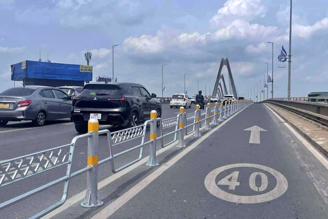 Hà Nội tiếp tục lắp hàng rào sắt phân làn cầu Nhật Tân - Ảnh 1.