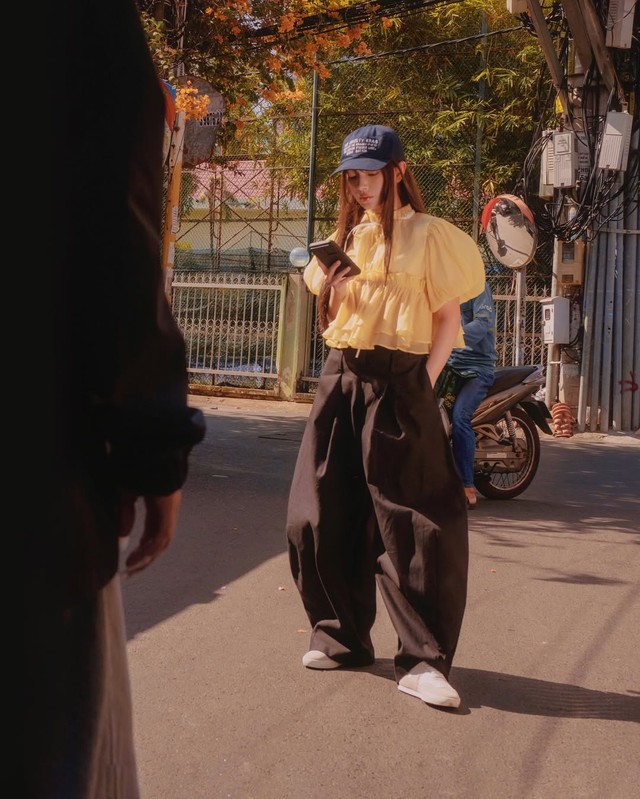 Kết hợp cùng một chiếc quần ống rộng tối màu, chẳng hạn như màu đen hoặc xám đen. Chiếc quần này không chỉ tạo nên sự tương phản màu sắc thú vị, mà còn giúp tổng thể trở nên hài hòa hơn