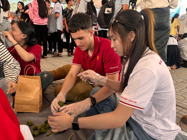 Sinh viên quốc tế lúng túng lần đầu gói bánh tét, đón Tết Việt giữa giảng đường - Ảnh 1.