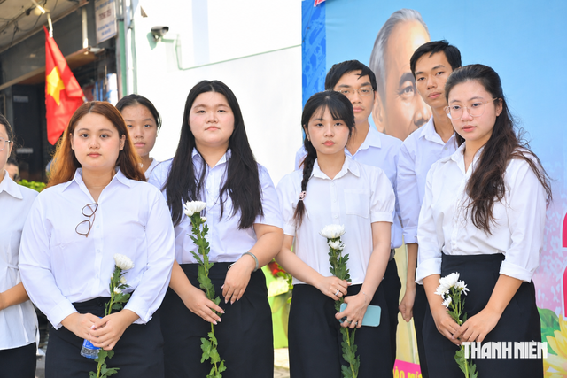 Người trẻ rưng rưng mang hoa trắng tiễn đưa các anh hùng liệt sĩ - Ảnh 1.
