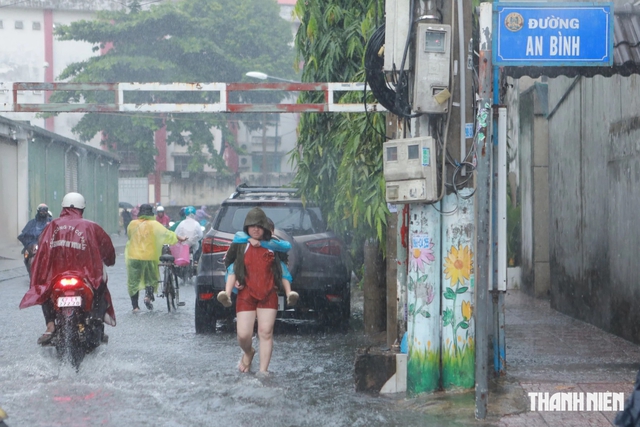 Mưa lớn giờ tan trường, nhiều học sinh ở TP.HCM lội nước về nhà - Ảnh 9.