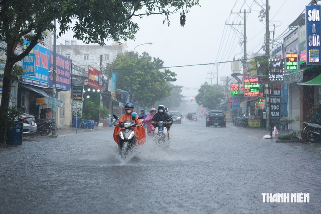 Mưa lớn giờ tan trường, nhiều học sinh ở TP.HCM lội nước về nhà - Ảnh 1.