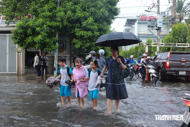 Mưa lớn giờ tan trường, nhiều học sinh ở TP.HCM lội nước về nhà - Ảnh 12.