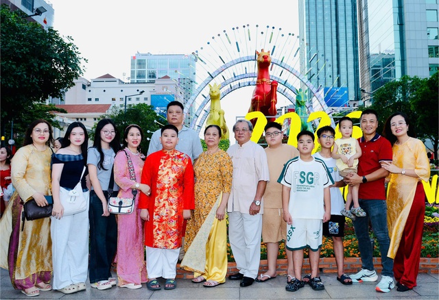 Gia đ&igrave;nh miền Bắc v&agrave;o TP.HCM ăn tết: Ấn tượng mai v&agrave;ng ngập lối - Ảnh 2.